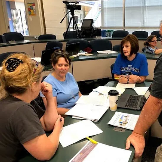 Teachers at a table discussing results 