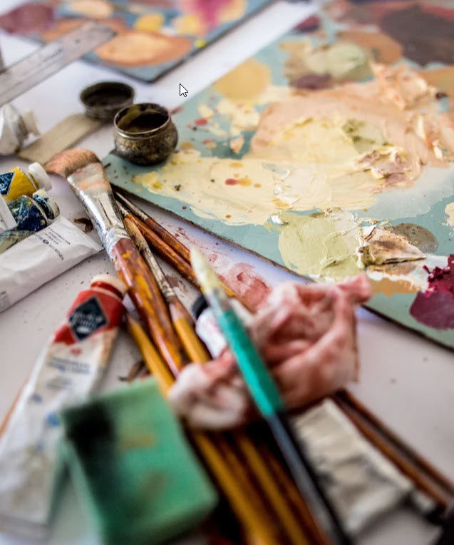 paint brushes on a table with various colored paints 