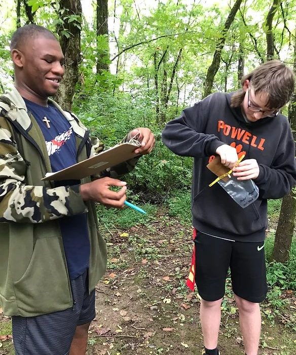Two students collecting and recording data in the field. 